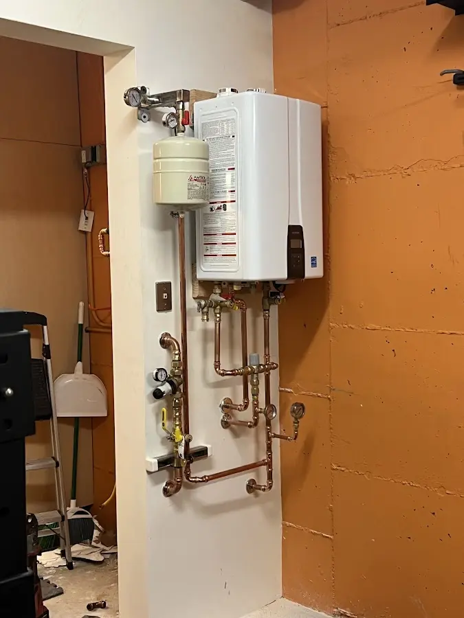 Plumbing technician inspecting water heater connections in Whitemarsh